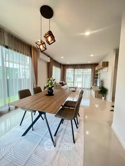 Spacious modern living room with elegant dining area and large windows for natural light.