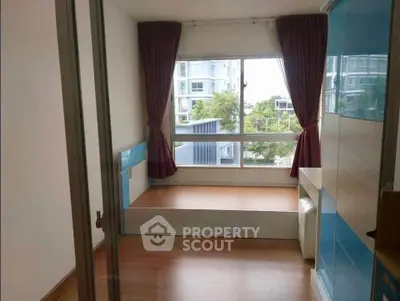 Modern bedroom with large window and built-in storage in urban apartment