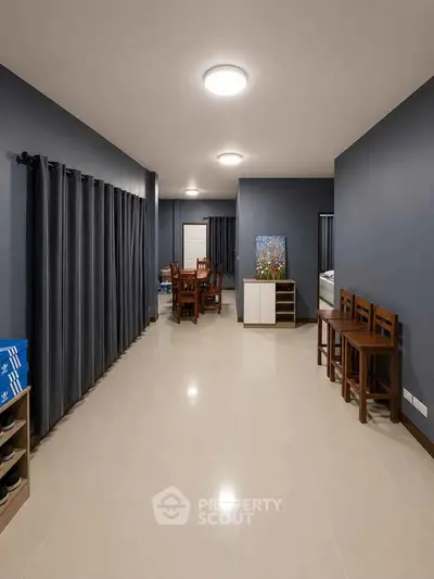 Spacious modern living room with sleek tile flooring and elegant dark curtains.
