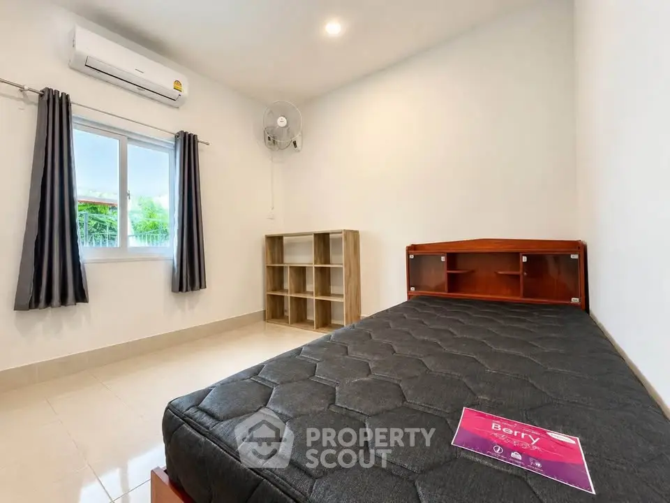 Spacious bedroom with modern furnishings and natural light, featuring a comfortable bed and ample storage space.