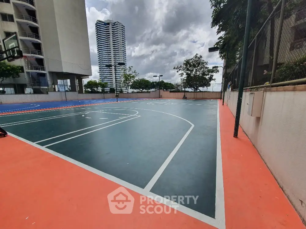Spacious outdoor basketball court with city skyline view, perfect for sports enthusiasts in urban living.