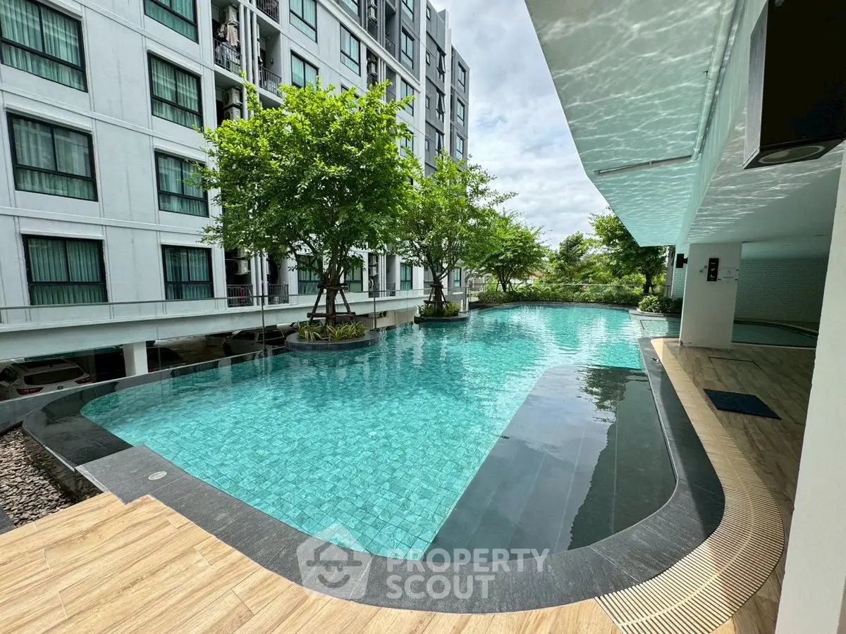 Luxurious modern apartment complex with stunning outdoor pool and lush greenery.