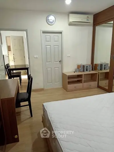 Spacious bedroom with modern furniture and ample storage in a cozy apartment.
