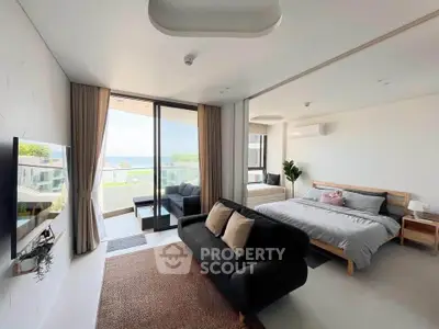 Luxurious modern bedroom with ocean view and stylish decor, featuring a cozy seating area and large windows.