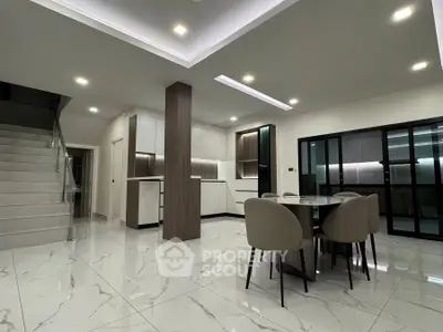 Spacious modern living area with elegant dining set and sleek staircase