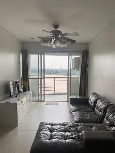 Spacious living room with leather sofa and balcony view
