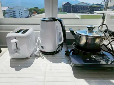 Modern kitchen appliances on a sunny countertop with a scenic view.