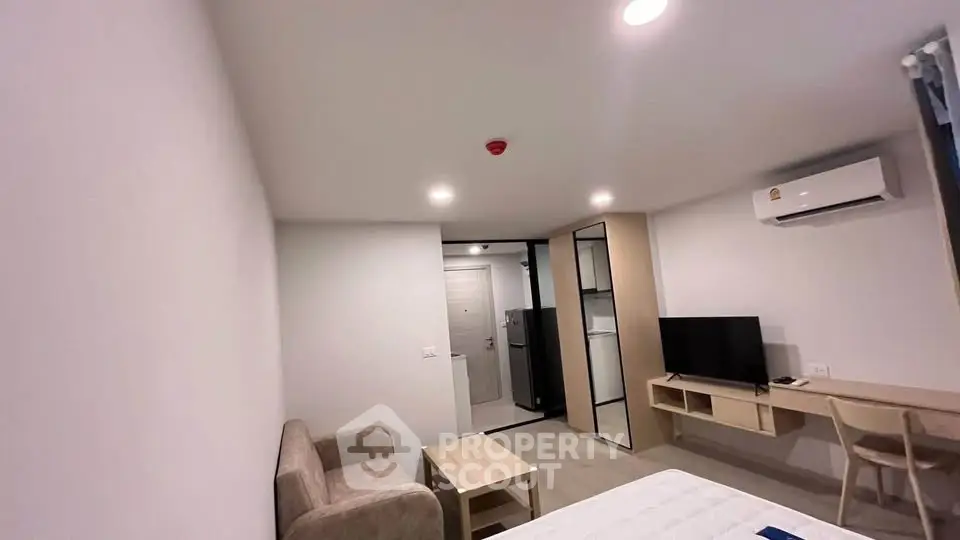 Modern studio apartment with minimalist design, featuring a cozy living area and efficient use of space.