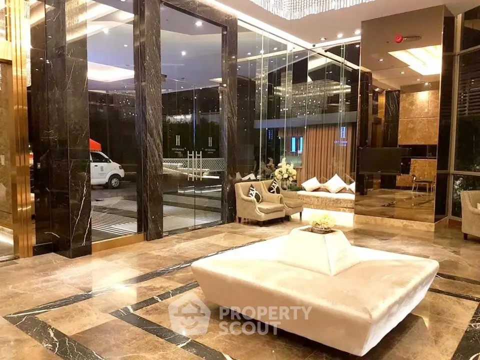 Luxurious building entrance with elegant marble flooring and plush seating area.
