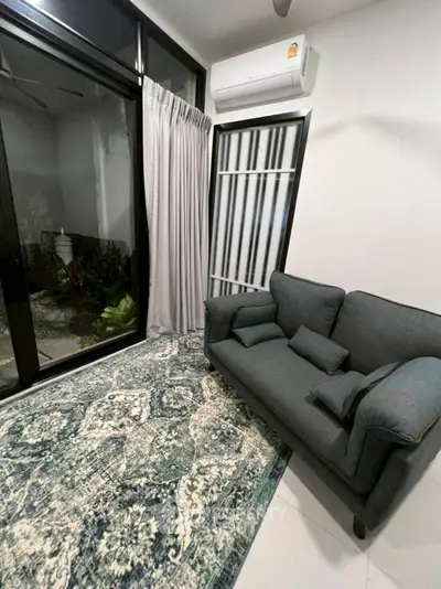 Cozy living room with modern sofa and large window overlooking garden