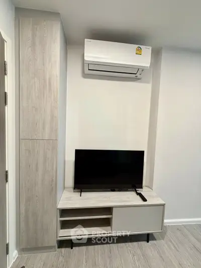 Modern living room with sleek TV stand and air conditioning unit, perfect for comfortable living.