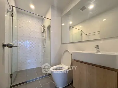 Modern bathroom with glass shower and sleek fixtures in a contemporary home.