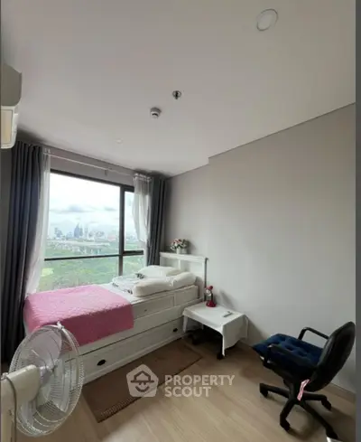 Cozy bedroom with city view, featuring modern decor and natural light.