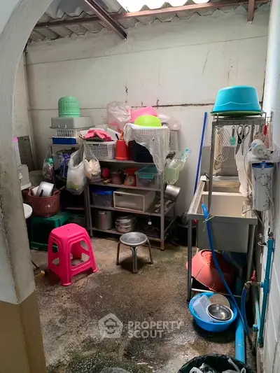 Compact storage area with various kitchen items and cleaning supplies.