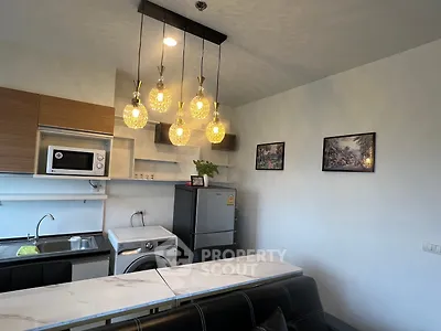 Modern kitchen with stylish lighting, washing machine, and sleek appliances.