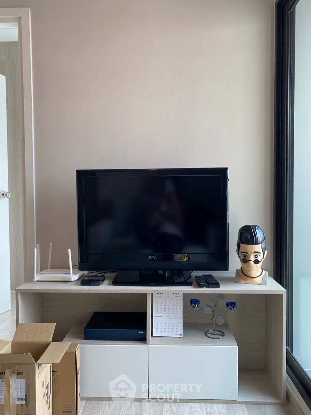 Modern living room with sleek TV stand and large window, perfect for cozy entertainment.