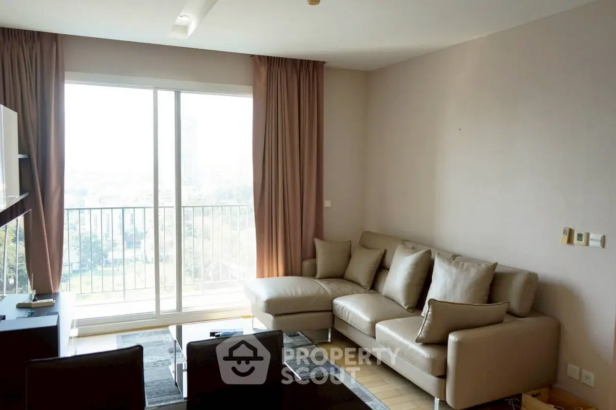 Spacious living room with modern sofa and large window offering city view