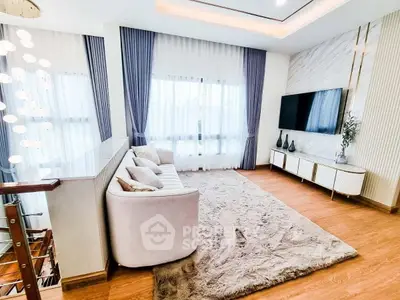Luxurious living room with elegant decor, plush rug, and modern entertainment setup.