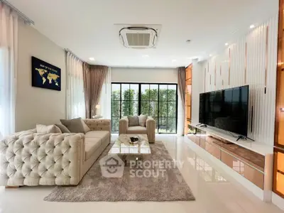 Luxurious living room with plush sofas, large TV, and elegant decor, perfect for relaxation and entertainment.