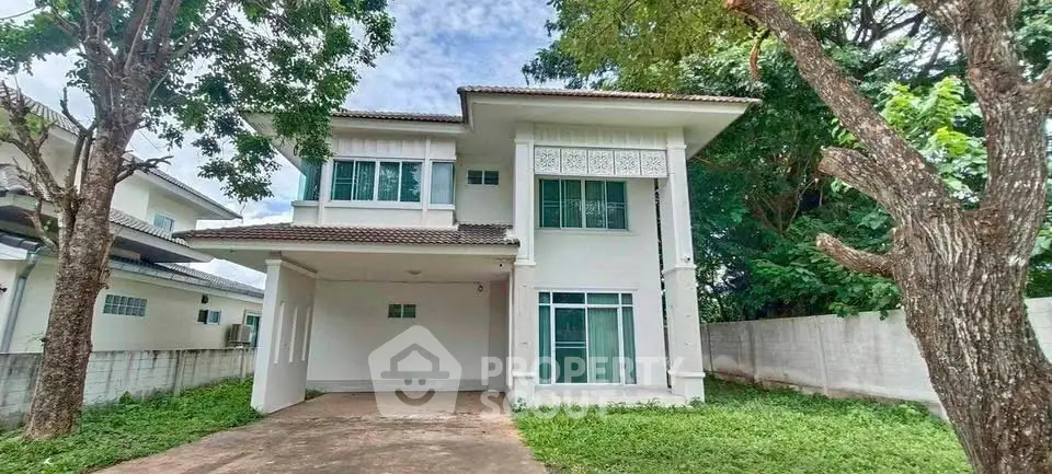 Charming two-story house with lush greenery and spacious driveway