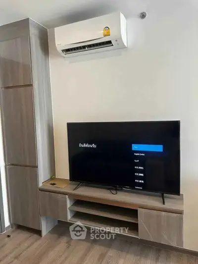 Modern living room with sleek TV unit and air conditioning in a stylish apartment.