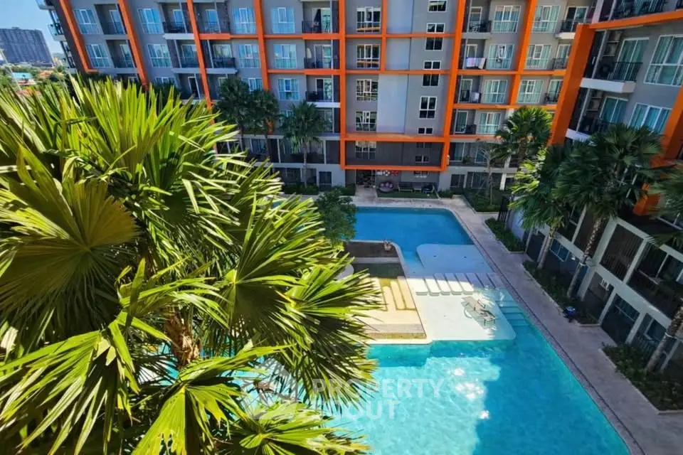 Modern apartment complex with spacious pool and lush greenery