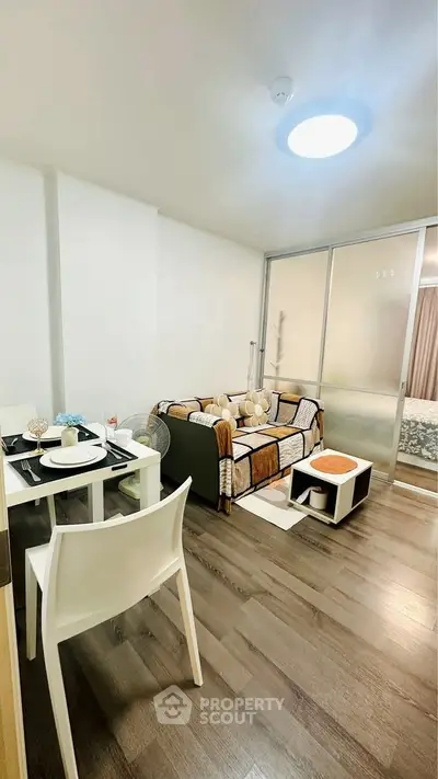 Modern living room with cozy decor and dining area in open layout apartment.