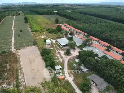 Aerial view of rural residential area with lush greenery and farmland, showcasing peaceful countryside living.