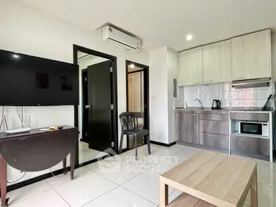 Modern apartment interior with open kitchen and living area, featuring sleek appliances and stylish decor.