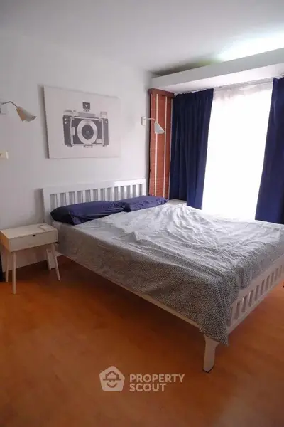 Cozy bedroom with stylish decor and natural light, featuring a comfortable bed and modern furnishings.