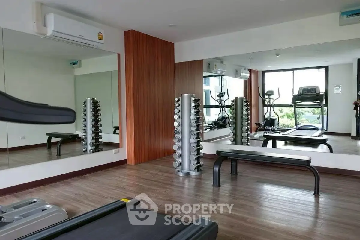Modern gym with mirrored walls and fitness equipment in a residential building