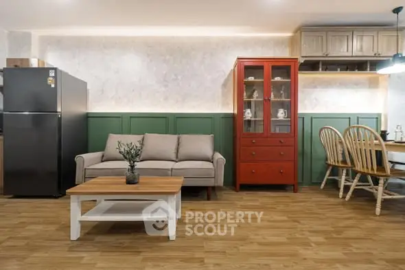 Charming living room with cozy sofa, vibrant red cabinet, and elegant dining area.