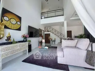 Elegant living room with high ceiling, modern decor, and a cozy sofa set, complemented by an artistic staircase leading to an upper level.