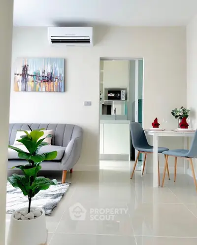 Modern living room with cozy sofa and dining area in open layout apartment.