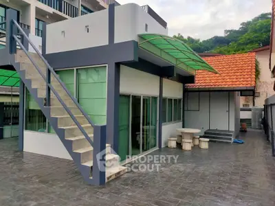 Modern two-story building with outdoor staircase and tiled patio