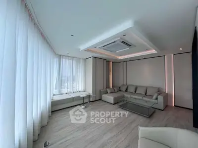 Luxurious modern living room with sleek design and large windows offering abundant natural light.