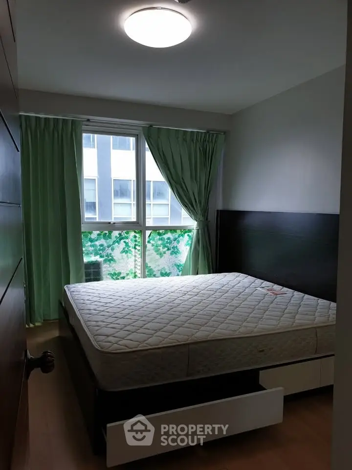 Cozy bedroom with large window and green curtains, featuring a comfortable bed and modern design.