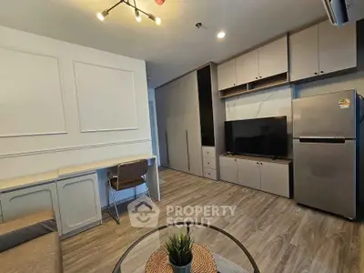 Modern living room with sleek furniture and built-in storage, featuring a flat-screen TV and stylish lighting.