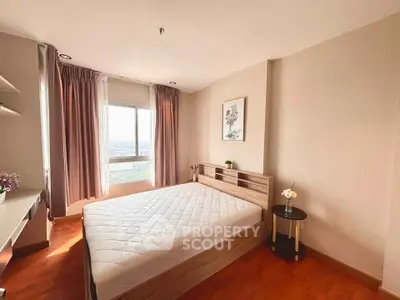 Spacious bedroom with large window and elegant decor, offering a serene and inviting atmosphere.
