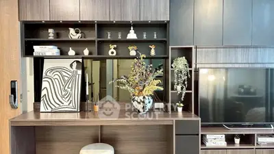 Stylish living room with modern shelving and decor, featuring a sleek TV setup.