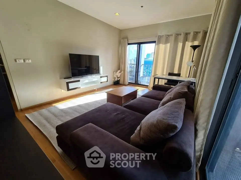 Spacious living room with modern decor and large windows offering natural light.