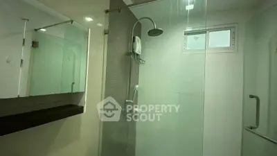 Modern bathroom with glass shower enclosure and sleek fixtures