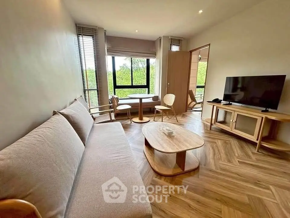 Spacious living room with modern furniture and large windows offering a serene view.
