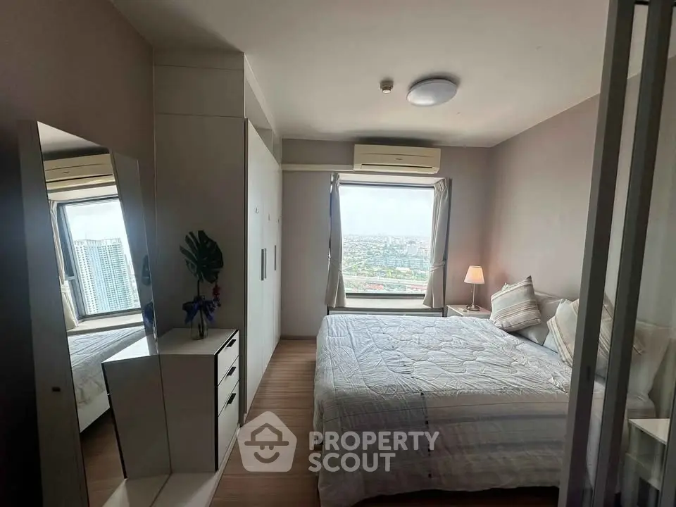 Cozy bedroom with city view, featuring a comfortable bed, modern wardrobe, and ample natural light.