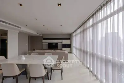 Spacious modern living room with large windows and elegant dining area in luxury apartment.