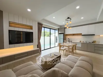 Modern open-plan living room with elegant decor and pool view, featuring cozy seating and stylish dining area.