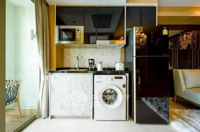 Modern kitchen with sleek appliances and washing machine in a stylish apartment.