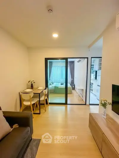 Modern open-plan living room with dining area and kitchen in a cozy apartment.