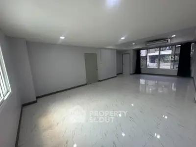 Spacious empty room with large windows and modern flooring, ideal for customization.