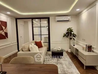 Modern living room with stylish decor and air conditioning, featuring a cozy sofa and elegant lighting.